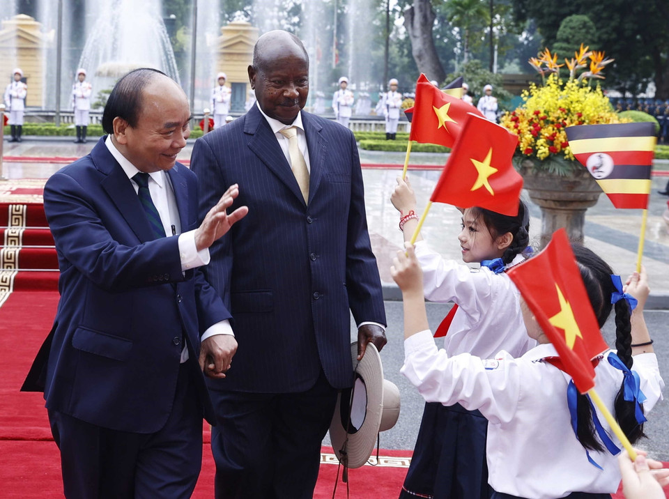 Chủ tịch nước Nguyễn Xuân Phúc và Tổng thống Uganda Yoweri Kaguta Museve với thiếu nhi Hà Nội tại lễ đón. (Ảnh: Thống Nhất/TTXVN)