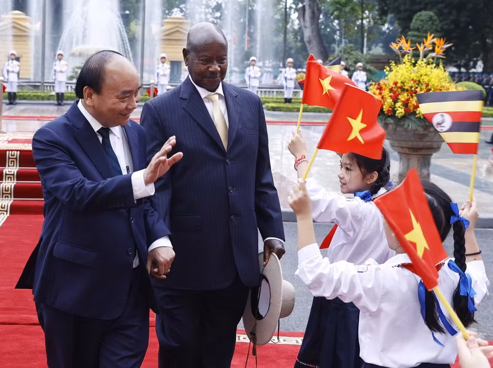 Chủ tịch nước Nguyễn Xuân Phúc và Tổng thống Uganda Yoweri Kaguta Museve với thiếu nhi Hà Nội tại lễ đón. (Ảnh: Thống Nhất/TTXVN)