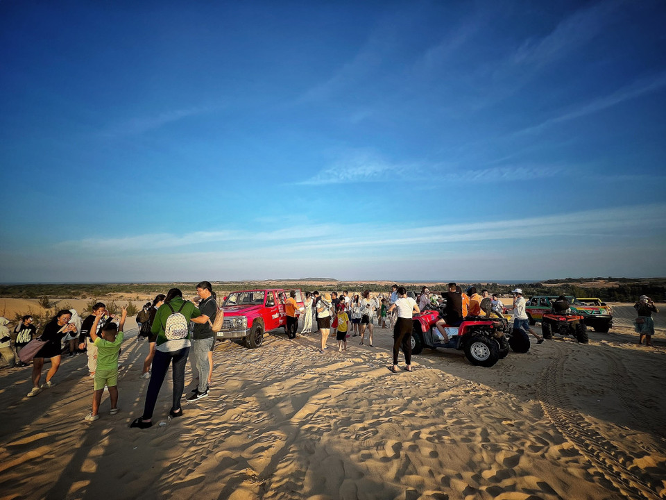 Du khách tấp nập đến trải nghiệm bàu cát trắng. (Ảnh: Mai Mai/Vietnam+)