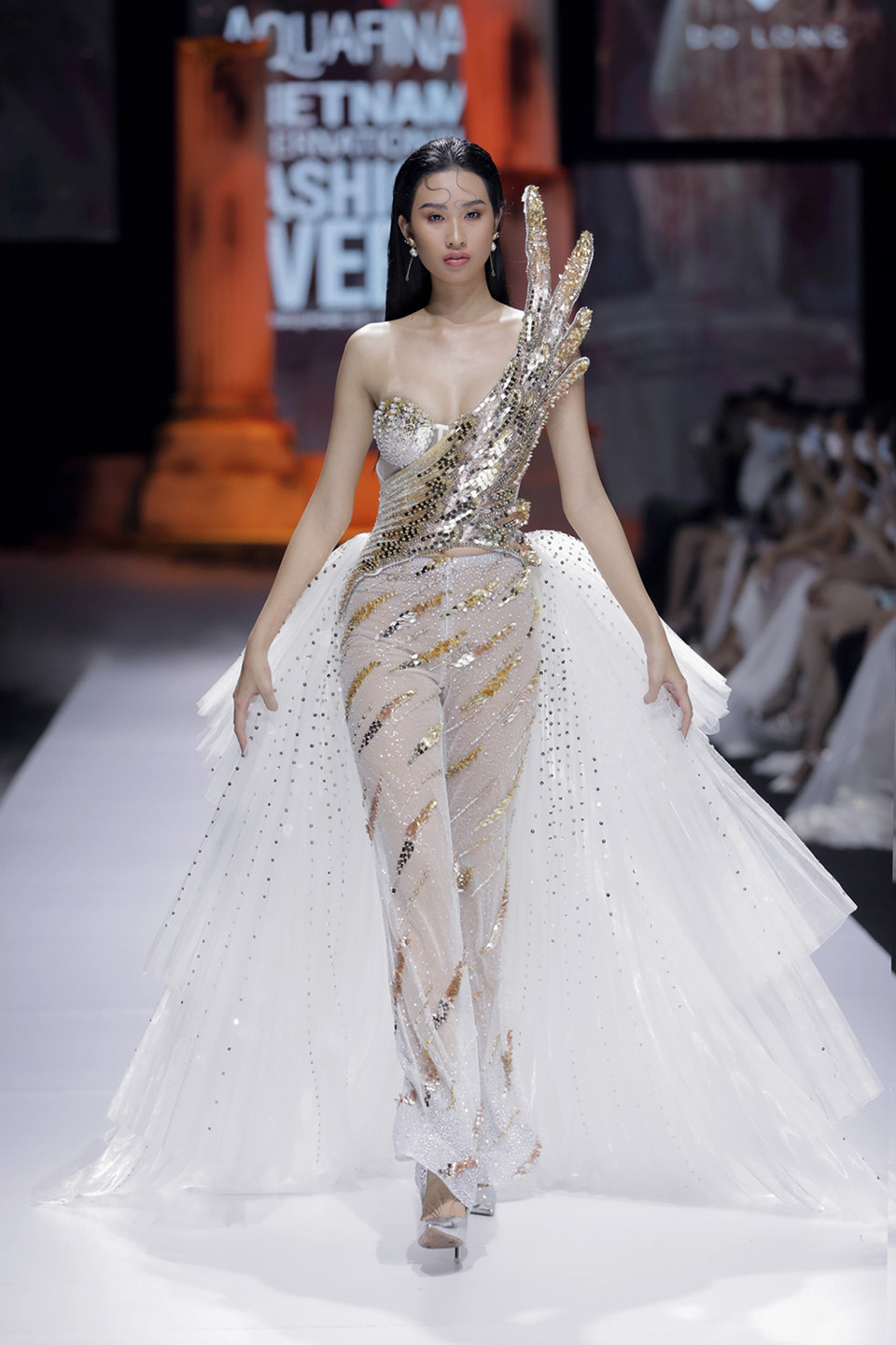 Lấy cảm hứng từ những bức tượng trong thần thoại Hy Lạp, Chất liệu chủ yếu của bộ sưu tập là chiffon, voan tơ mềm mại bay bổng, và các chất liệu ánh kim thêu đính cầu kỳ. Những thiết kế chủ yếu là phom xòe bay bổng, xếp nếp bằng vải chiffon kết hợp chi tiết lông vũ và họa tiết cách điệu từ hoa văn Hy Lạp cổ đại. (Ảnh: CTV/Vietnam+)