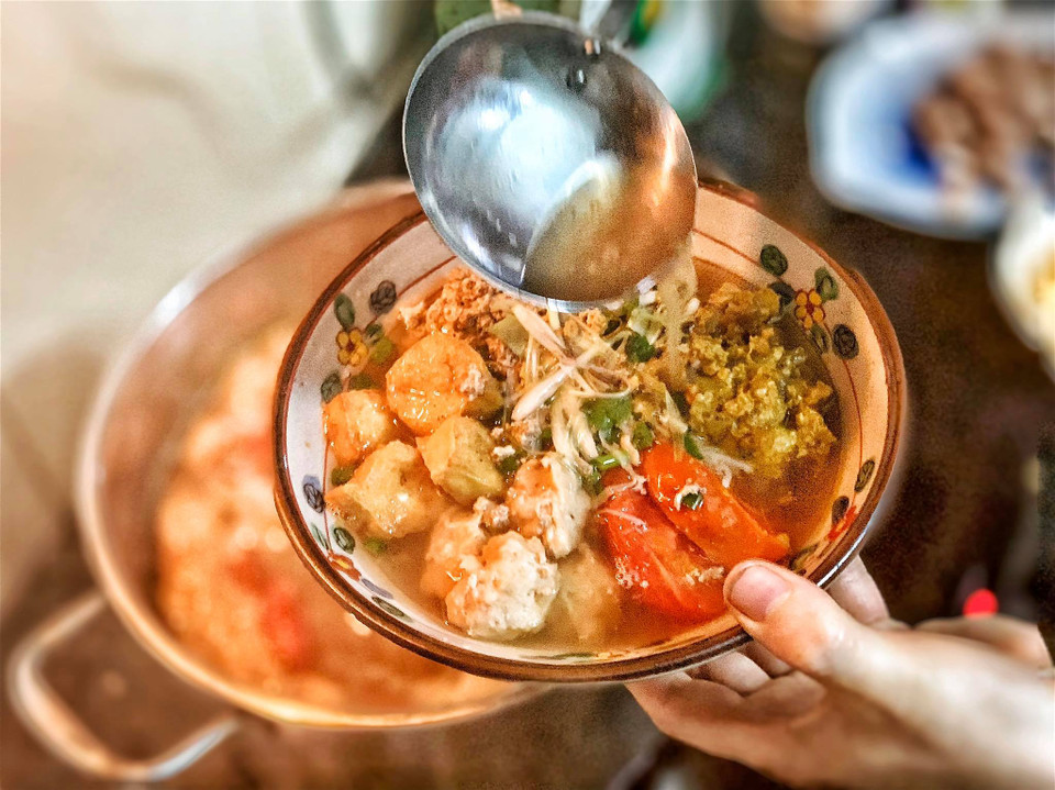 Cho bún ra bát, chan thêm nước riêu cua có vị thơm ngọt, chua thanh dịu, thêm tôm thịt viên, đậu rán, cua chưng. (Ảnh: Mai Mai/Vietnam+)