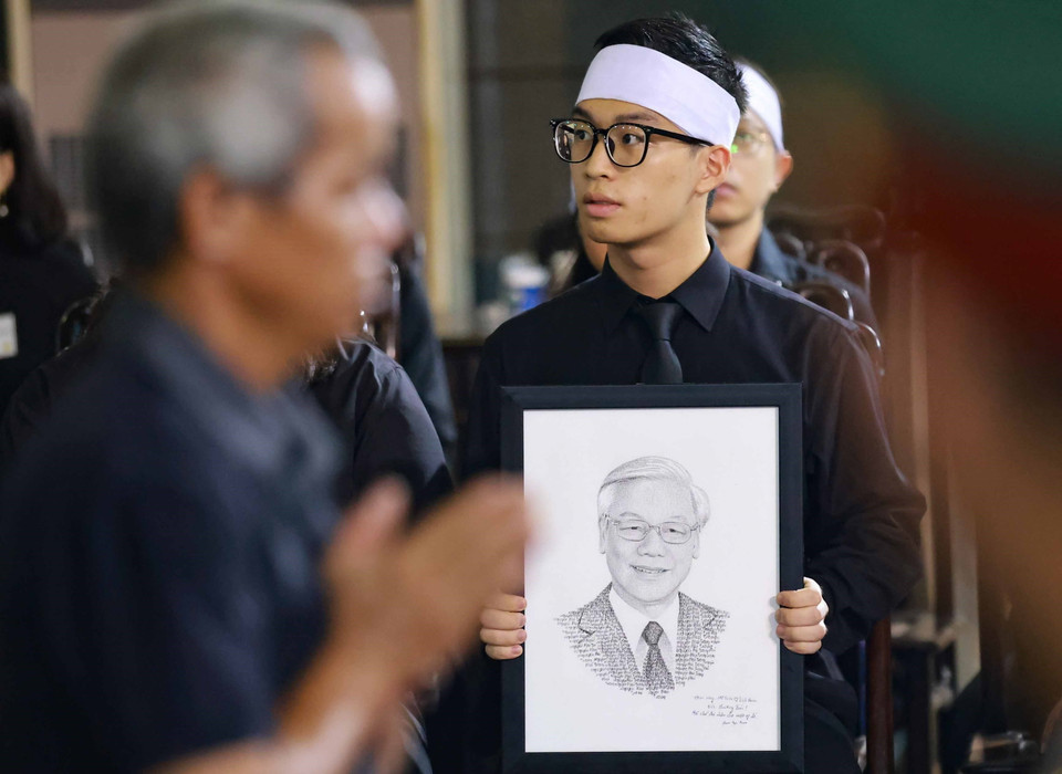 Bức chân dung với nụ cười đôn hậu của Tổng Bí thư Nguyễn Phú Trọng làm người dân tới viếng không khỏi xúc động, bùi ngùi. (Ảnh: TTXVN)