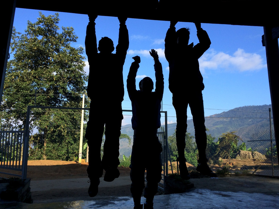 Dân 'trekking' (leo núi), dù là chuyên nghiệp hay không chuyên thì trước mỗi chuyến đi đều cần chuẩn bị cho mình sức khỏe thật tốt. Và đây là màn khởi động của các bạn trẻ trong một chuyến đi, ở nhà của 'porter' (người dẫn đường) bản địa dưới chân núi trước giờ khởi hành. (Ảnh: M.Mai/Vietnam+)