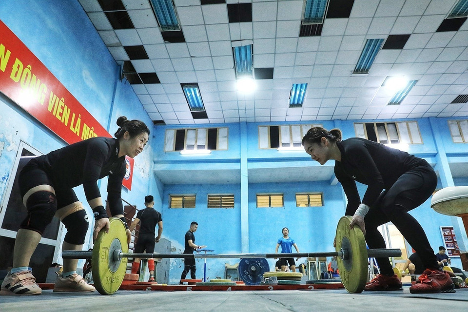 Các vận động viên lắp tạ trước khi tăng dần các bài tập nâng tạ. (Ảnh: Tuấn Anh/TTXVN)