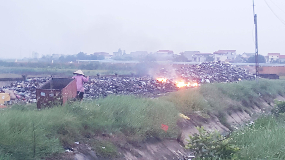 Người dân ở Tề Lỗ thu gom các loại chất thải do thóa dỡ xe, động cơ mang ra bãi rác gần khu dân cư đốt hủy vào mỗi buổi chiều. (Ảnh: Nguyễn Trọng Lịch/TTXVN)