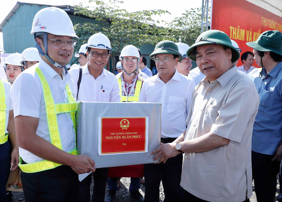 Thủ tướng Nguyễn Xuân Phúc tặng quà động viên các đơn vị và công nhân đang thi công. (Ảnh: Thống Nhất/TTXVN)