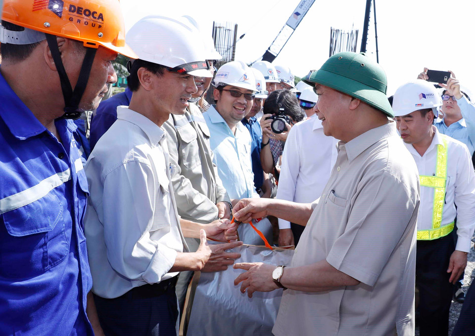 Thủ tướng Nguyễn Xuân Phúc tặng quà động viên các đơn vị và công nhân đang thi công. (Ảnh: Thống Nhất/TTXVN)