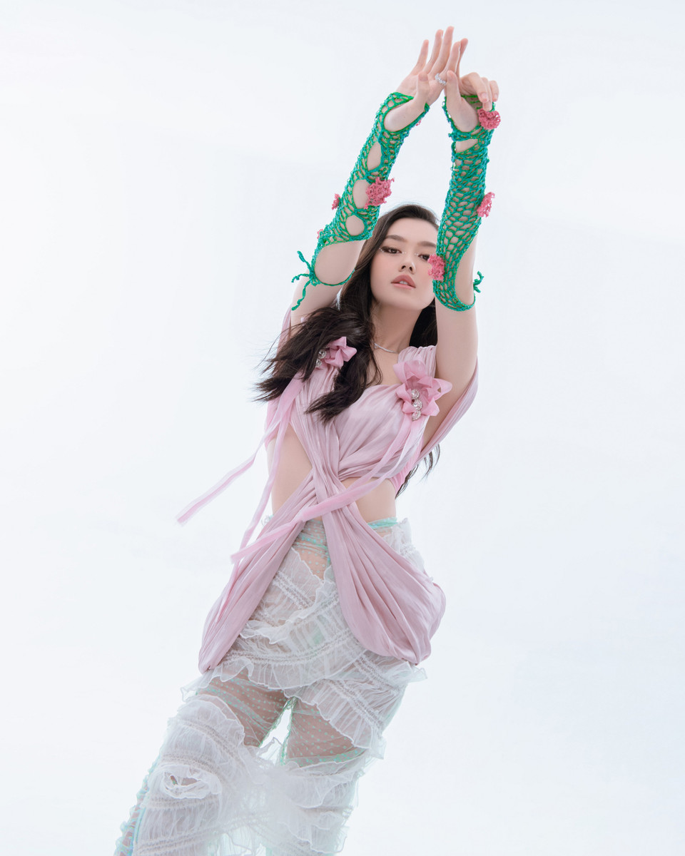 Bộ cánh được phối hợp bởi 3 items khác nhau có các tông màu tươi sáng. Chiếc áo cut-out suông rủ hồng nhạt kết hợp với chân váy voan dài kết hợp hai màu trắng-xanh. (Ảnh: CTV/Vietnam+)