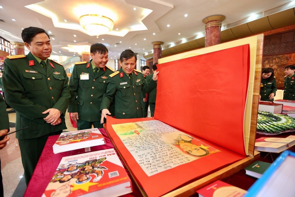 Các đại biểu tham quan trưng bày bài dự thi tìm hiểu 30 năm Ngày hội Quốc phòng toàn dân và 75 năm Ngày thành lập Quân đội nhân dân Việt Nam. (Ảnh: Dương Giang/TTXVN)