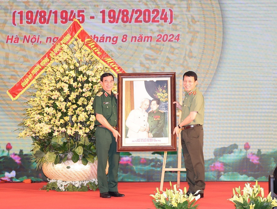 Thượng tướng, Bộ trưởng Công an Lương Tam Quang, thay mặt Đảng ủy Công an Trung ương, Bộ Công an trao tặng bức ảnh 'Bác Hồ và Đại tướng Võ Nguyên Giáp' cho Đại tướng, Bộ trưởng Quốc phòng Phan Văn Giang thay mặt Quân ủy Trung ương, Bộ Quốc phòng. (Ảnh: Trí Dũng/TTXVN)