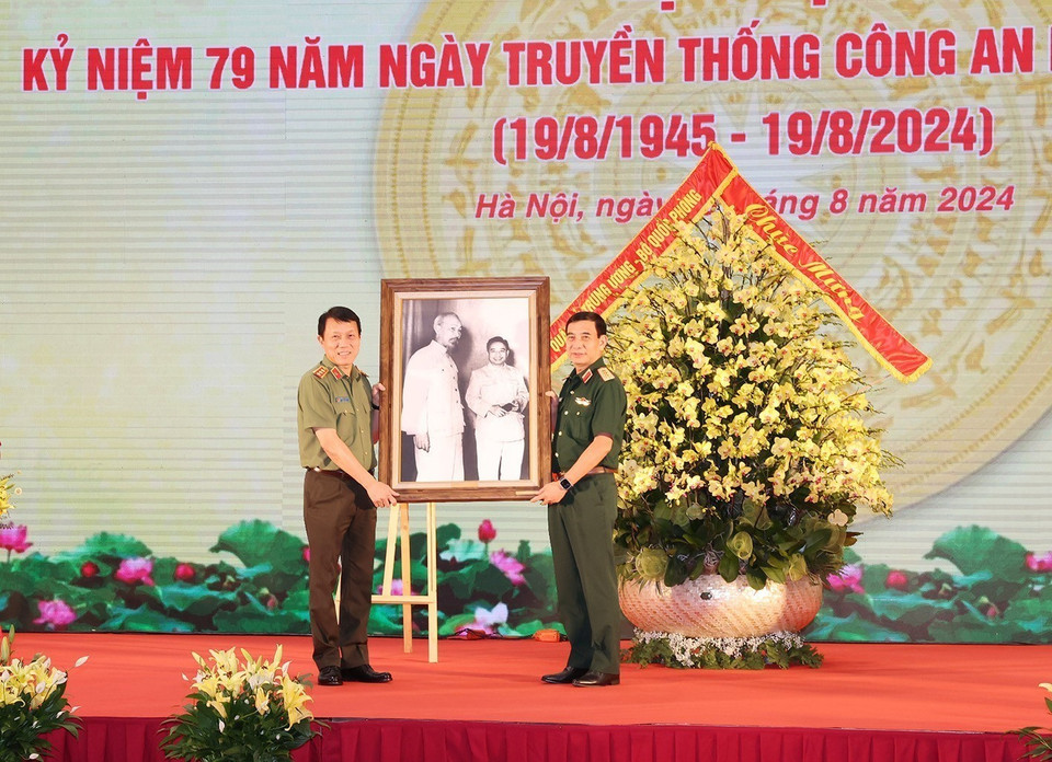Đại tướng, Bộ trưởng Quốc phòng Phan Văn Giang, thay mặt Quân ủy Trung ương, Bộ Quốc phòng trao tặng bức ảnh Bác Hồ cho Thượng tướng, Bộ trưởng Công an Lương Tam Quang, thay mặt Đảng ủy Công an Trung ương, Bộ Công an. (Ảnh: Trí Dũng/TTXVN)