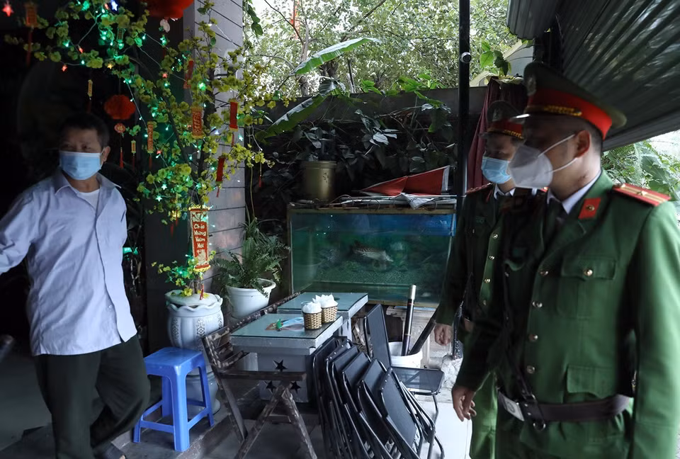 Lực lượng công an nhắc nhở người dân việc thực hiện đóng cửa quán càphê tại khu đô thị Văn Quán, quận Hà Đông. (Ảnh: Phan Tuấn Anh/TTXVN)