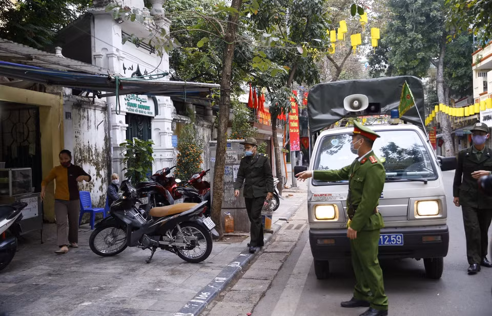 Lực lượng chức năng công an phường Hàng Mã ra quân đề nghị các hộ kinh doanh đóng cửa quán ăn đường phố, trà đá, càphê. (Ảnh: Doãn Tấn/TTXVN)