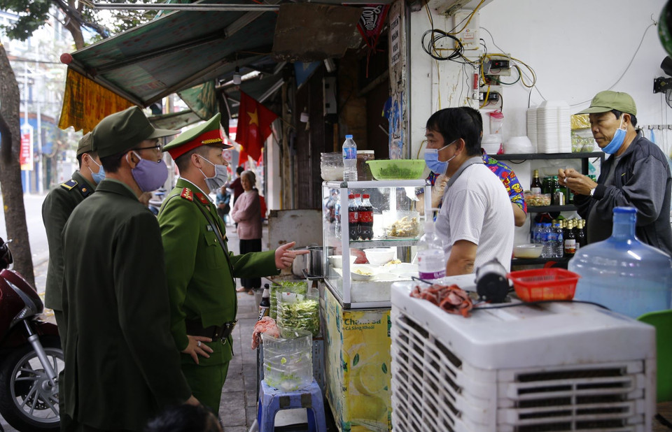  Lực lượng chức năng Công an phường Hàng Mã ra quân đề nghị các hộ kinh doanh đóng cửa quán ăn đường phố, trà đá, càphê. (Ảnh: Doãn Tấn/TTXVN)