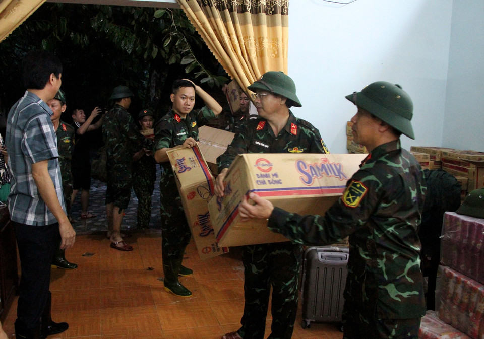 Bộ Chỉ huy Quân sự tỉnh Nghệ An trao hàng cứu trợ gồm các mặt hàng thiết yếu như nước sạch, mỳ tôm… cho đại diện huyện Kỳ Sơn. (Ảnh: Văn Tý/TTXVN)