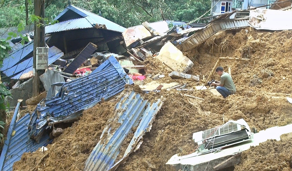 Phóng viên Trọng Đạt, Cơ quan thường trú Hòa Bình, tác nghiệp tại khu sạt lở xã Cuối Hạ, huyện Kim Bôi (Hòa Bình), sáng 12/9. (Ảnh: TTXVN)