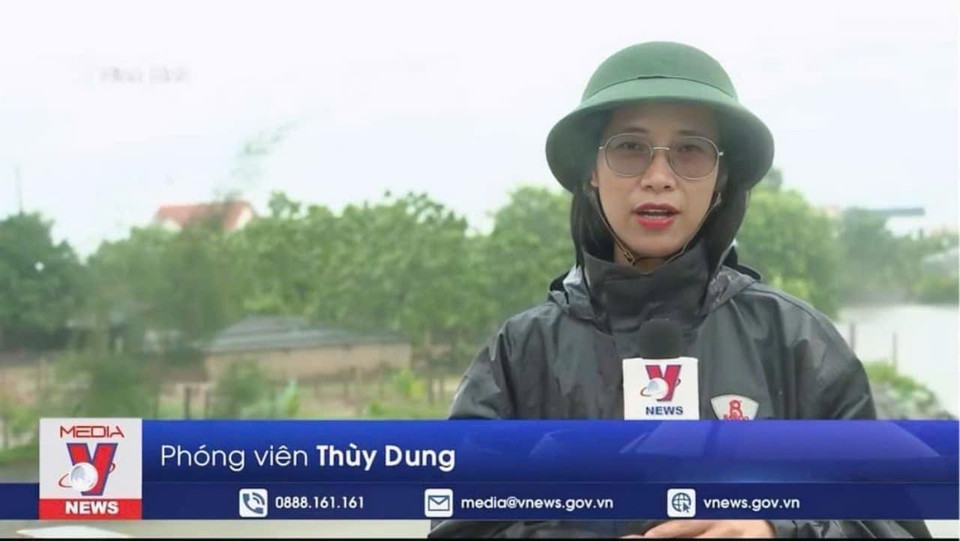 Phóng viên Thuỳ Dung, Cơ quan thường trú Ninh Bình, tác nghiệp về bão số 3 tại huyện Kim Sơn. (Ảnh: TTXVN)