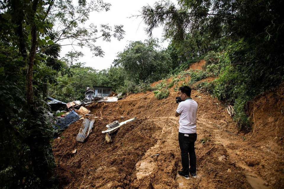 Phóng viên Bùi Thanh Hải, Cơ quan thường trú Hòa Bình, tác nghiệp tại khu sạt lở xã Cuối Hạ, huyện Kim Bôi (Hòa Bình) sáng 12/9. (Ảnh: TTXVN)