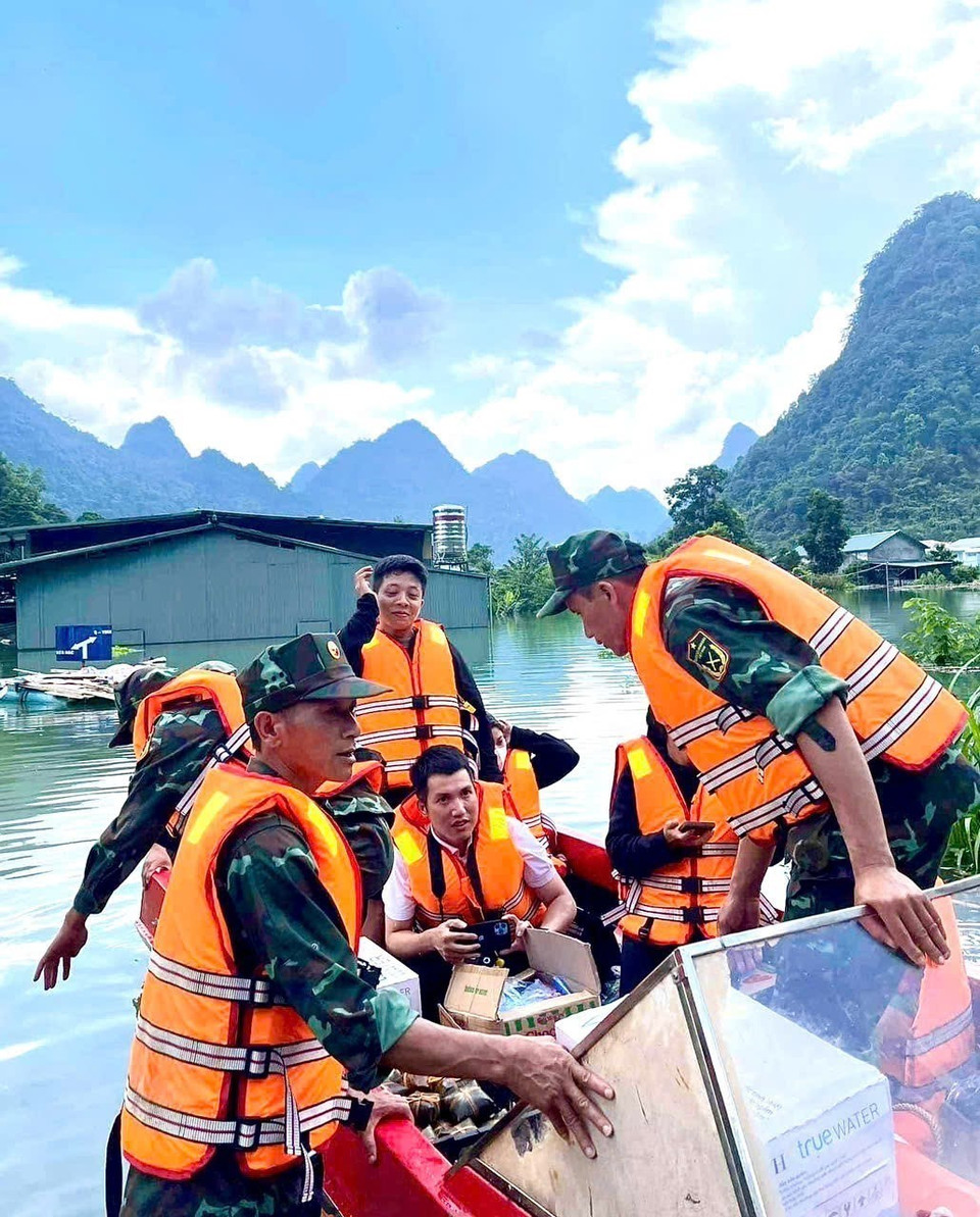 Phóng viên Chu Hiệu, Cơ quan thường trú Cao Bằng, tác nghiệp tại vùng ngập lụt xã Quang Vinh, huyện Trùng Khánh. (Ảnh: TTXVN)