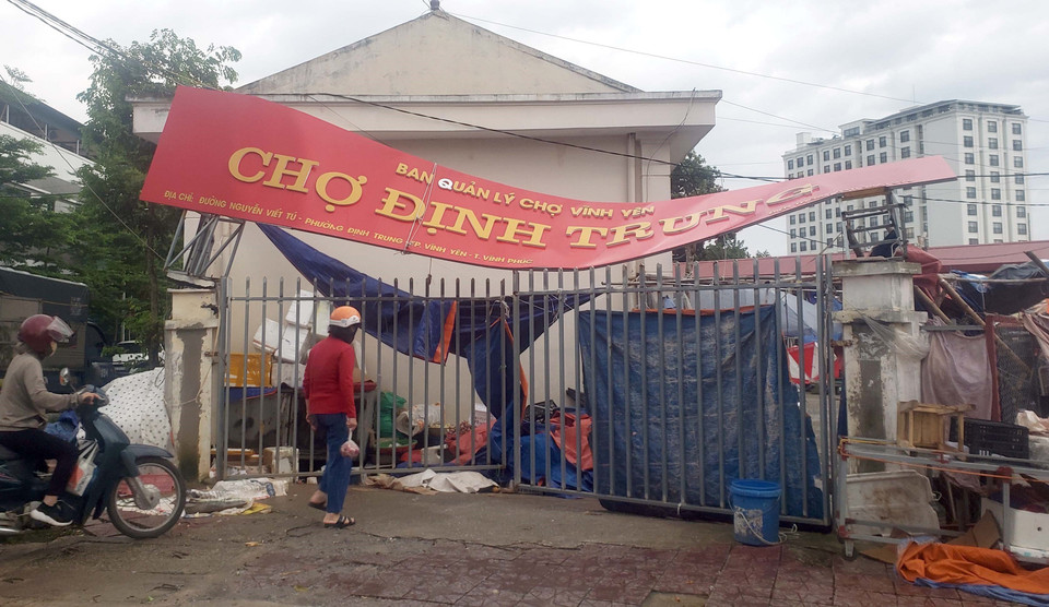 Tấm biển tại chợ phường Định Trung, thành phố Vĩnh Yên bị biến dạng do gió mạnh. (Ảnh: Hoàng Hùng/TTXVN)