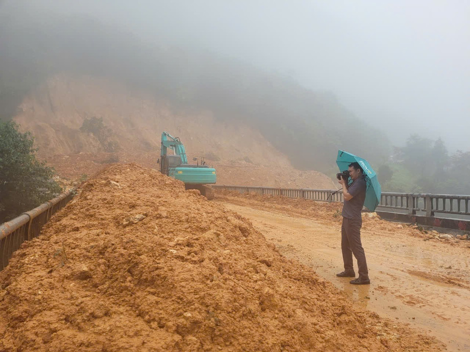 Phóng viên Nguyễn Oanh,Cơ quan thường trú Lai Châu, tác nghiệp tại điểm sạt lở ở xã Sơn Bình, huyện Tam Đường. (Ảnh: TTXVN)