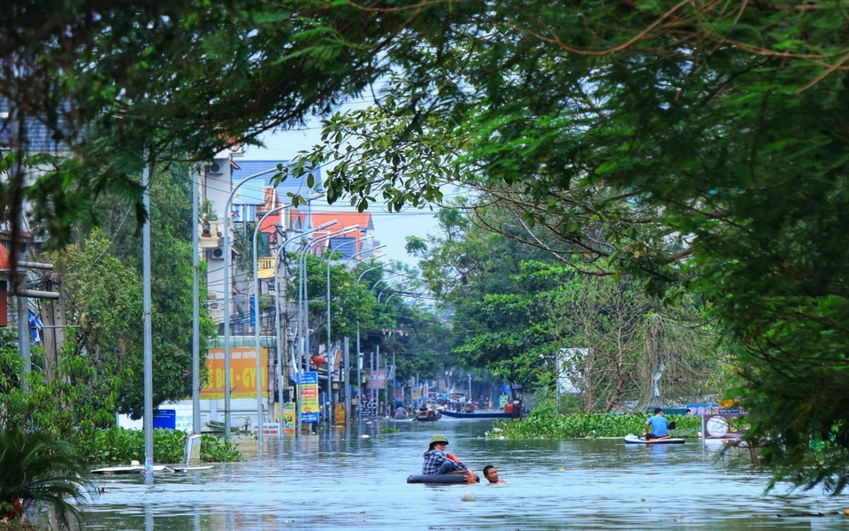 Người dân di chuyển bằng thuyền trong khu vực bị ngập. (Ảnh: Tuấn Anh/TTXVN)