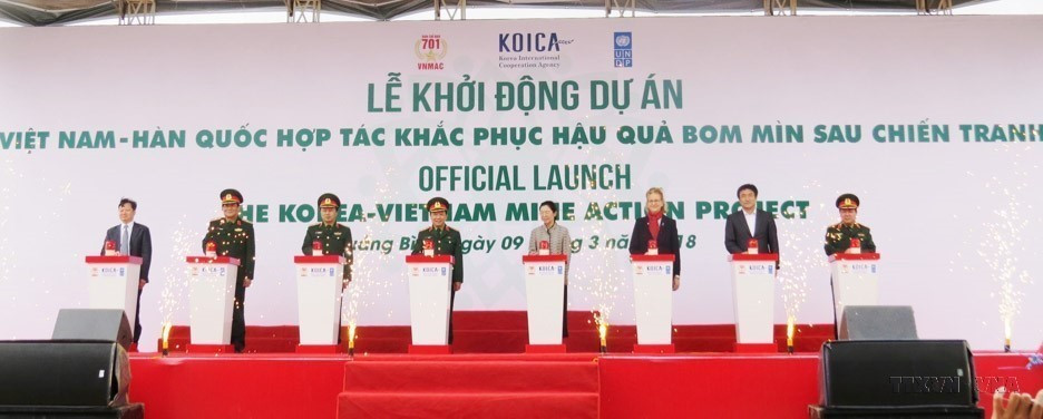 Các đại biểu thực hiện nghi thức bấm nút khởi động Dự án 'Việt Nam-Hàn Quốc hợp tác khắc phục hậu quả bom mìn sau chiến tranh,' được triển khai tại 2 tỉnh Quảng Bình và Bình Định (2018). (Ảnh: Võ Dung/TTXVN)