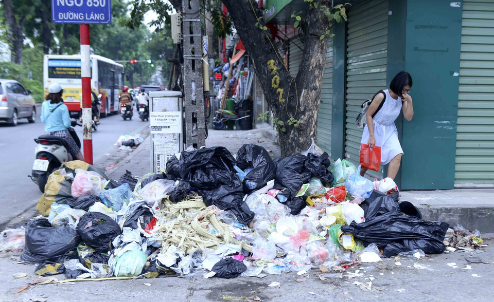 Những bãi rác tại đường Láng khiến người đi đường khó chịu vì bốc mùi. (Ảnh: Tuấn Đức/TTXVN)