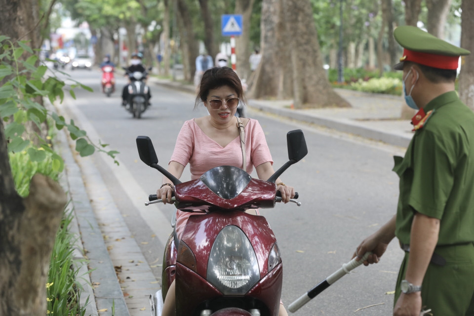 Lực lượng chức năng nhắc nhở, xử lý các trường hợp không đeo khẩu trang nơi công cộng. (Ảnh: Minh Quyết/TTXVN)