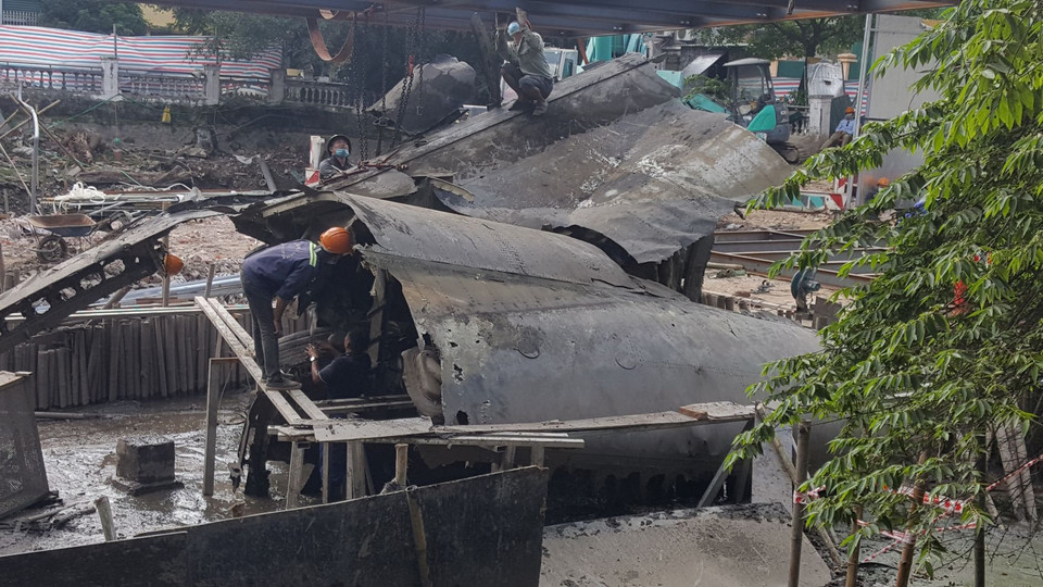 Đơn vị thi công tiến hành móc cẩu xác máy bay B52 ra khỏi vị trí cũ. (Ảnh: Đinh Thuận/TTXVN)