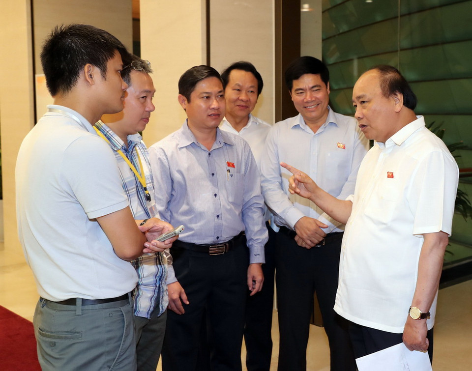  Thủ tướng Nguyễn Xuân Phúc và các đại biểu Quốc hội trao đổi bên lề phiên chất vấn và trả lời chất vấn. (Ảnh: Trọng Đức/TTXVN)