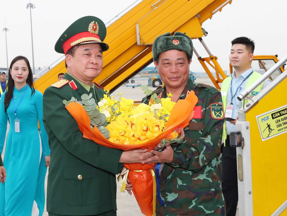 Thượng tướng Hoàng Xuân Chiến, Thứ trưởng Bộ Quốc phòng ra tận chân cầu thang máy bay tặng hoa đón các thành viên trong đoàn. (Ảnh: Trọng Đức/TTXVN)
