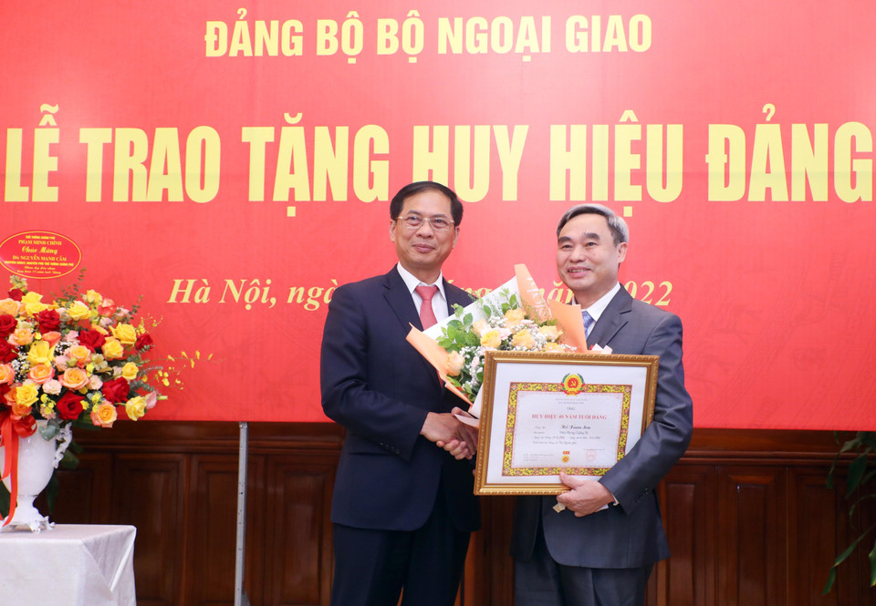 Bộ trưởng Bộ Ngoại giao Bùi Thanh Sơn trao Huy hiệu 40 năm tuổi Đảng tặng ông Hồ Xuân Sơn, nguyên Ủy viên Trung ương Đảng, nguyên Thứ trưởng Bộ Ngoại giao. (Ảnh: Lâm Khánh/TTXVN)