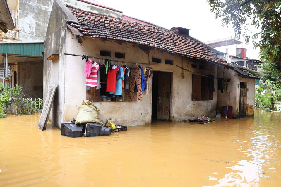 Nước sông Thương từ thượng nguồn đổ về nhanh cộng với nước từ trên núi đá cao tràn xuống làm nhiều nhà dân ở thị trấn Đồng Mỏ, huyện Chi Lăng nhanh chóng bị ngập sâu. (Ảnh: Phạm Hậu/TTXVN)