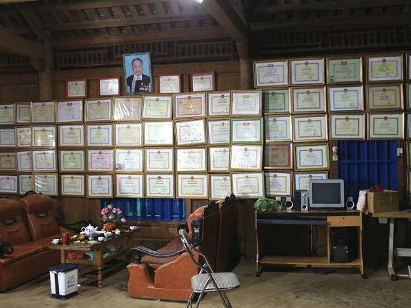 Giấy khen treo kín bốn vách nhà của một "già làng" ở Loóng Luông. (Ảnh: ChiLê/Vietnam+)