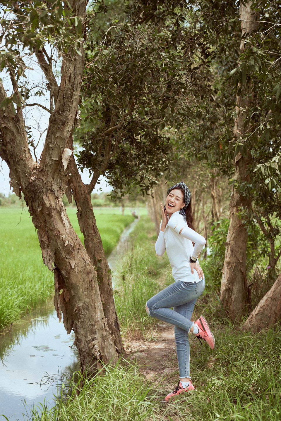 Với trang phục giản dị, quấn khăn rằn trên đầu, Hoa hậu Khánh Vân xin phép chủ nhà được tham quan ruộng lúa và vườn cây xung quanh. (Ảnh: Sang Đào/Vietnam+)