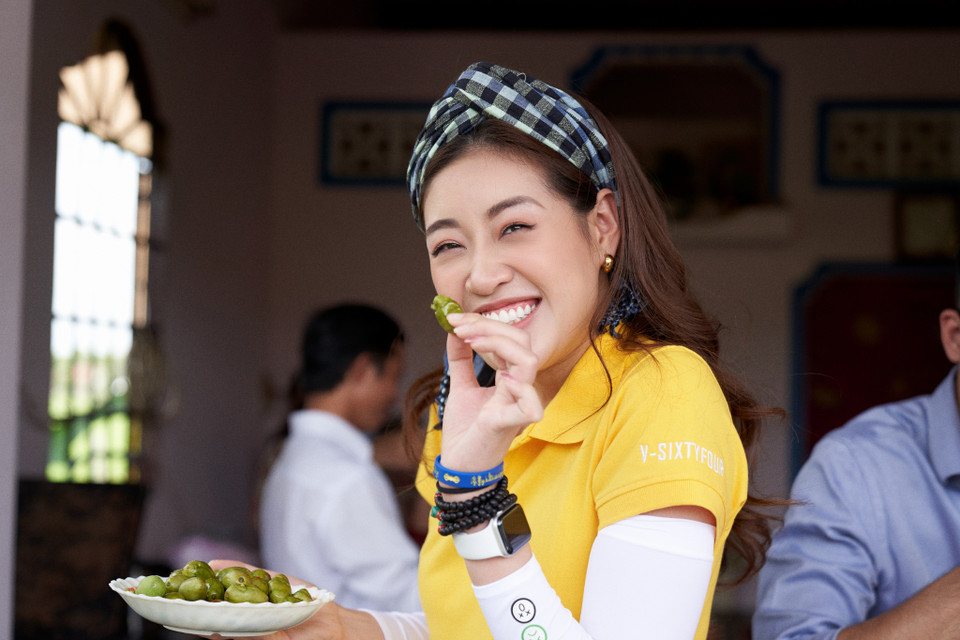 Hoa hậu được chủ nhà chiêu đãi món cà na trồng trong vườn nhà. Dù vị có hơi chua khiến cô phải nhăn mặt nhưng sau đó, người đẹp đã xin gia chủ mang về để ăn thêm vì ghiền. (Ảnh: Sang Đào/Vietnam+)