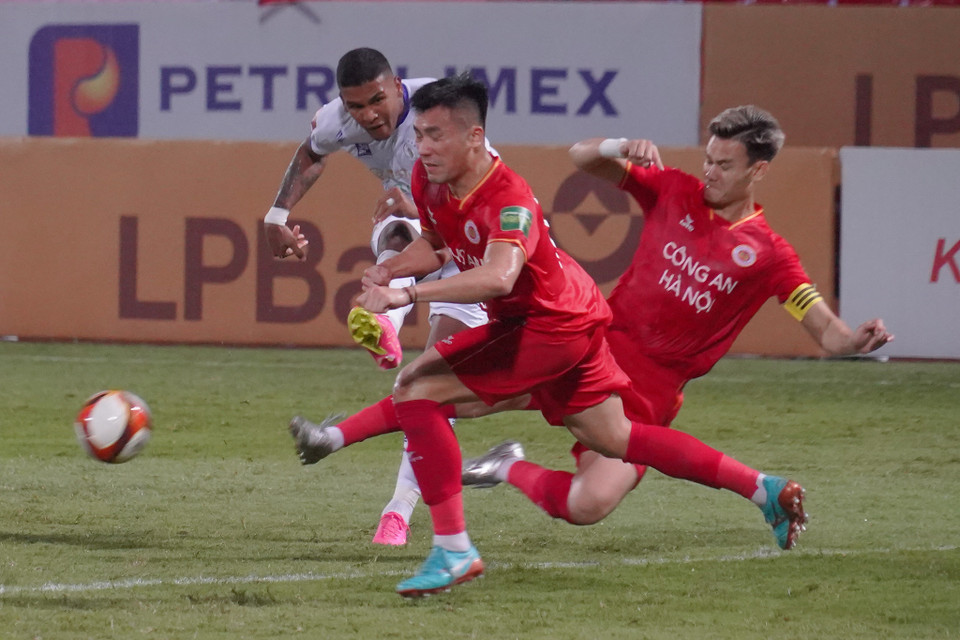 Hồ Tấn Tài và đồng đội vất vả khi truy cản tiền đạo Caion bên phía Câu lạc bộ Hà Nội. (Ảnh: Việt Anh/Vietnam+)