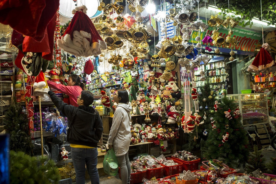 Du khách tham quan và chọn mua các mặt hàng trang trí đón Giáng sinh trên phố Hàng Mã. (Ảnh: Hoàng Hùng/TTXVN)