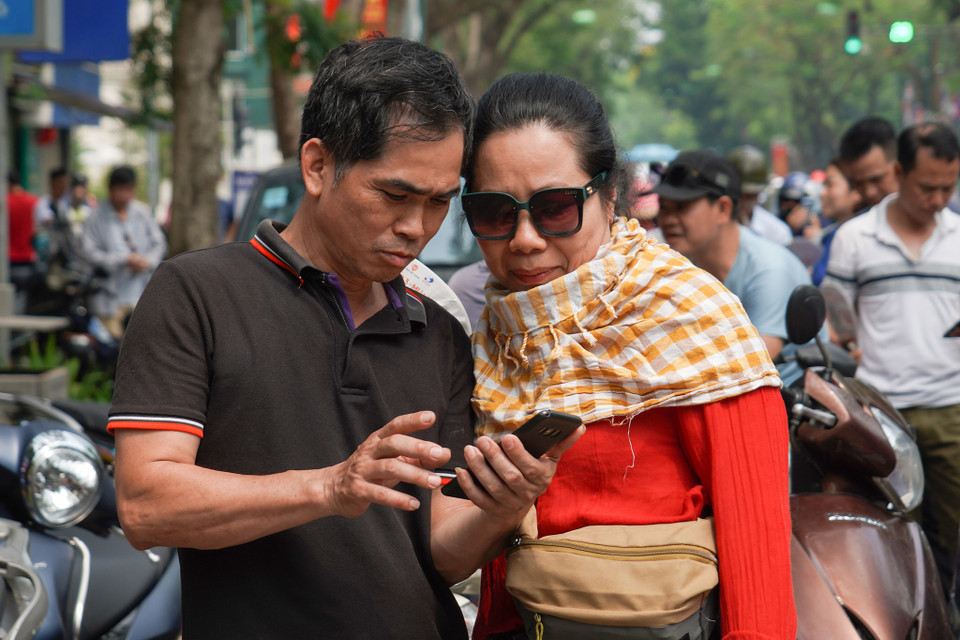 Bên ngoài điểm thi, các phụ huynh cũng bàn luận sôi nổi về các thông tin đề thi được đăng tải trên các mạng xã hội. (Ảnh: PV/Vietnam+)