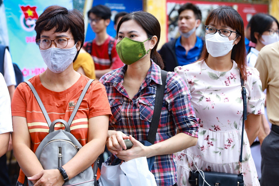 Bất chấp thời tiết oi bức tại Thủ đô, các bậc phụ huynh vẫn xếp hàng dài bên ngoài điểm thi để theo dõi tình hình làm bài thi của các sỹ tử. (Ảnh: PV/Vietnam+)