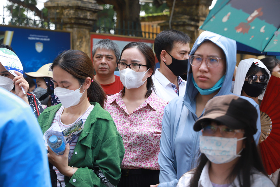 Đứng ngoài đợi con nhưng lòng cha mẹ không yên, chỉ mong con bình tĩnh để hoàn thành bài thi tốt nhất có thể. (Ảnh: PV/Vietnam+)