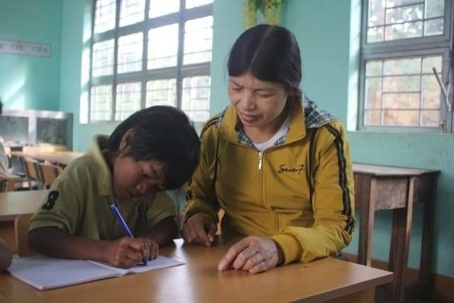 Để có thể ngồi dạy chữ cho các em, giáo viên phải vượt qua những đoạn đường khó khăn, vất vả đến trường. (Ảnh: Hồng Điệp/TTXVN)