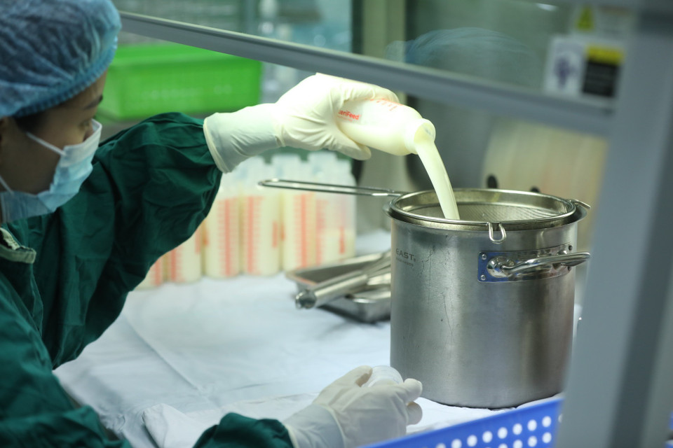 Nhân viên y tế thực hiện quy trình sàng lọc, bảo quản sữa. (Ảnh: Minh Quyết/TTXVN)