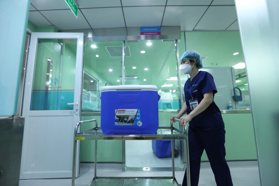 Nhân viên y tế vận chuyển sữa đã thanh trùng lên khoa cho các bé đang được điều trị. (Ảnh: Minh Quyết/TTXVN)