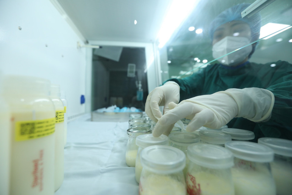 Nhân viên y tế thực hiện quy trình bảo quản sữa. (Ảnh: Minh Quyết/TTXVN)