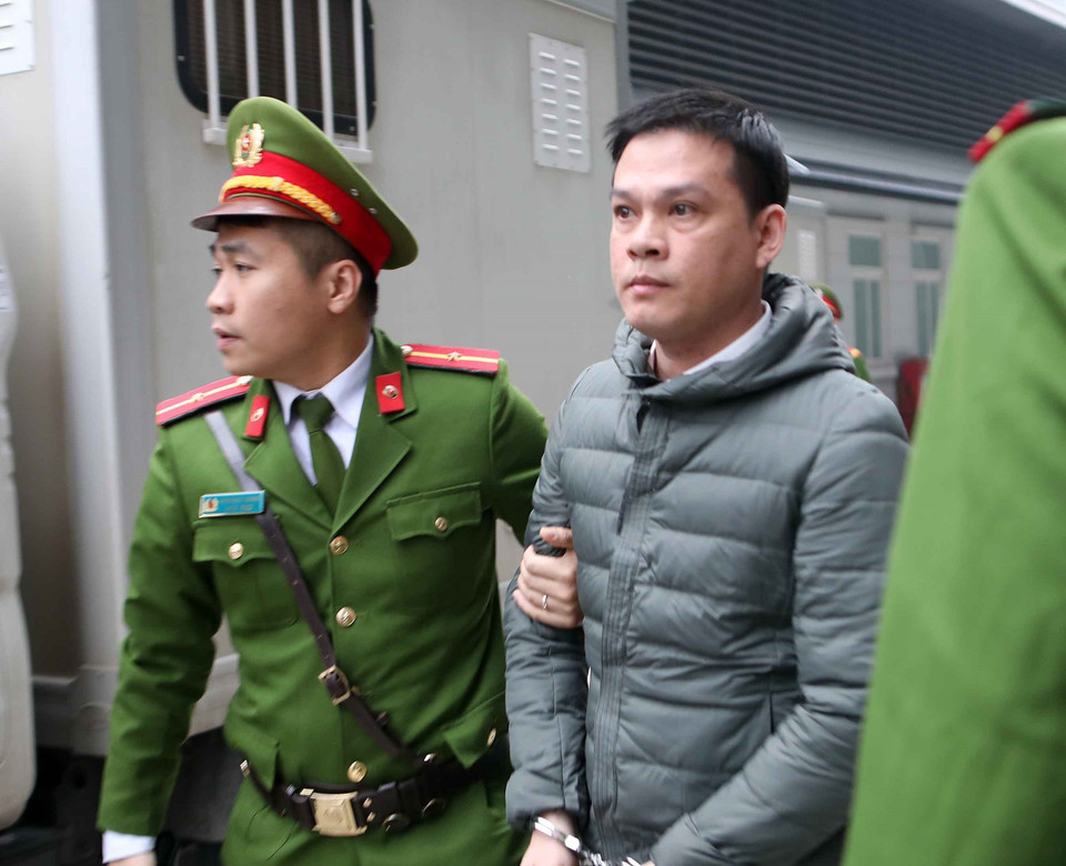 Cảnh sát dẫn giải bị cáo đến tòa xét xử. (Ảnh: Doãn Tấn/TTXVN)