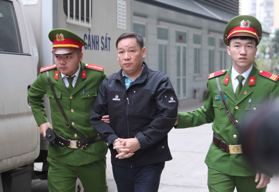 Cảnh sát dẫn giải bị cáo đến tòa xét xử. (Ảnh: Doãn Tấn/TTXVN)