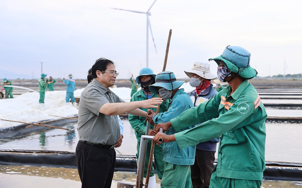 Thủ tướng Phạm Minh Chính gặp gỡ các diêm dân trên cánh đồng muối xã Phước Minh, huyện Thuận Nam. (Ảnh: Dương Giang/TTXVN)