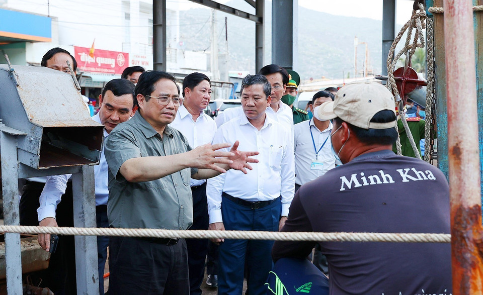 Thủ tướng Phạm Minh Chính thăm hỏi, động viên ngư dân tàu cá đang neo đậu tại cảng cá xã Cà Ná, huyện Thuận Nam. (Ảnh: Dương Giang/TTXVN)